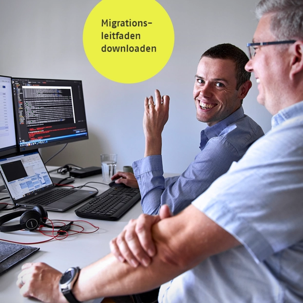 Zwei Personen besprechen sich am PC-Arbeitsplatz.