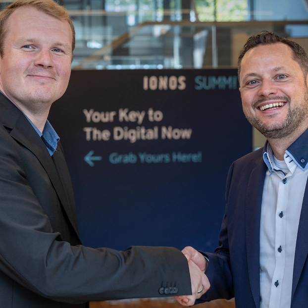  Oliver von Kleist, Partner Manager Cloud bei ]init[, und Tim Kartali, Head of Global Partner Sales bei IONOS besiegeln mit einem Handschlag für gemeinsame Partnerschaft.